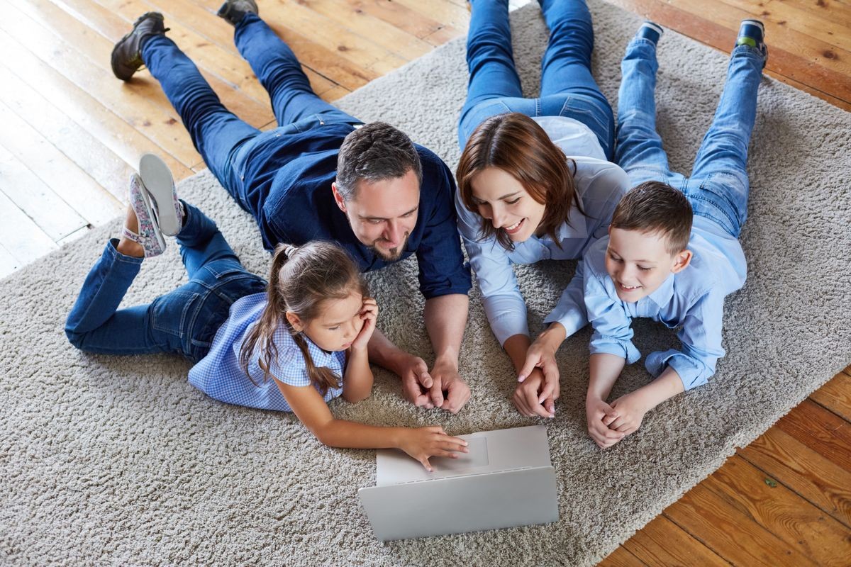 A family at home watching a movie at the laptop. Happy family at home looking at laptop.